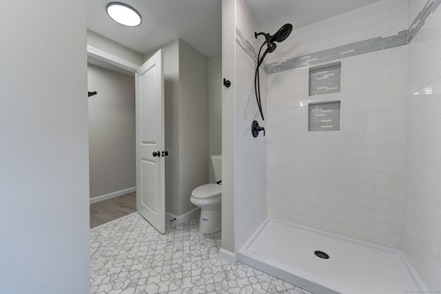 full bath with toilet, a shower stall, and baseboards