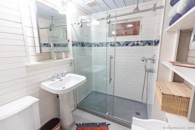 bathroom featuring a shower stall, toilet, visible vents, and a sink