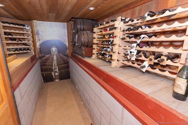 wine area with concrete flooring and wooden ceiling