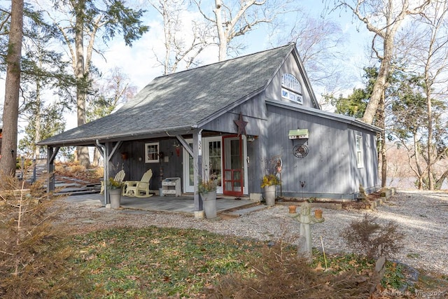 exterior space with a patio area and a shingled roof