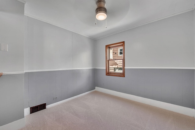 spare room with a ceiling fan, visible vents, and carpet flooring