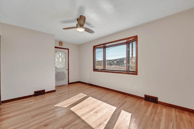 unfurnished room featuring light wood-style floors, baseboards, and visible vents