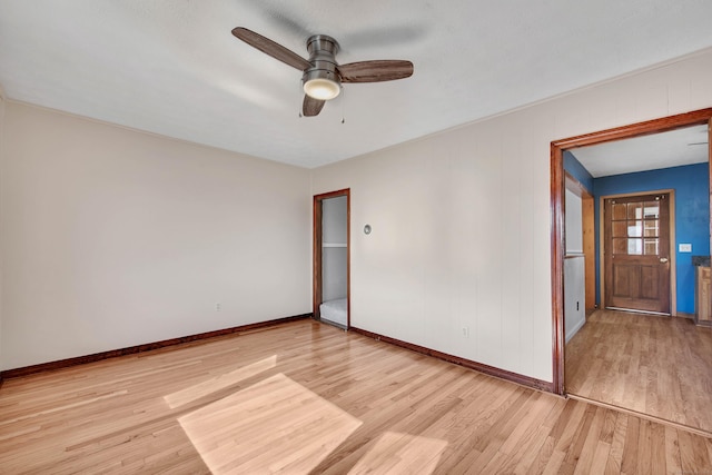 unfurnished room featuring wood finished floors, a ceiling fan, and baseboards