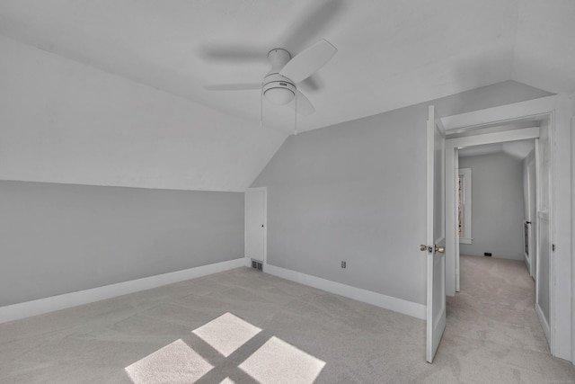 bonus room with vaulted ceiling, baseboards, and light colored carpet