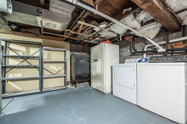 basement featuring heating fuel, separate washer and dryer, and freestanding refrigerator