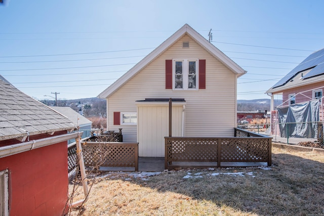 rear view of property featuring fence