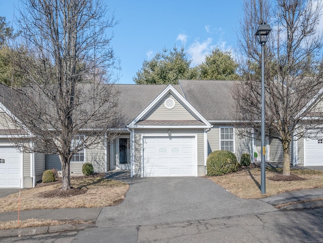 view of front of property with a garage, a shingled roof, and aphalt driveway