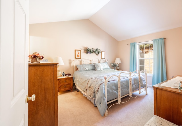 bedroom with lofted ceiling and light colored carpet