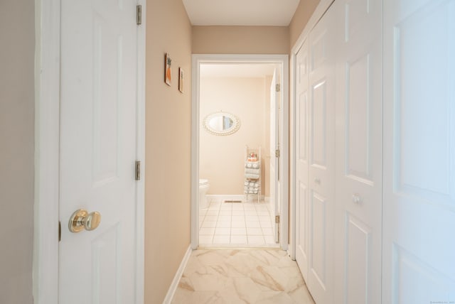 hallway with marble finish floor and baseboards