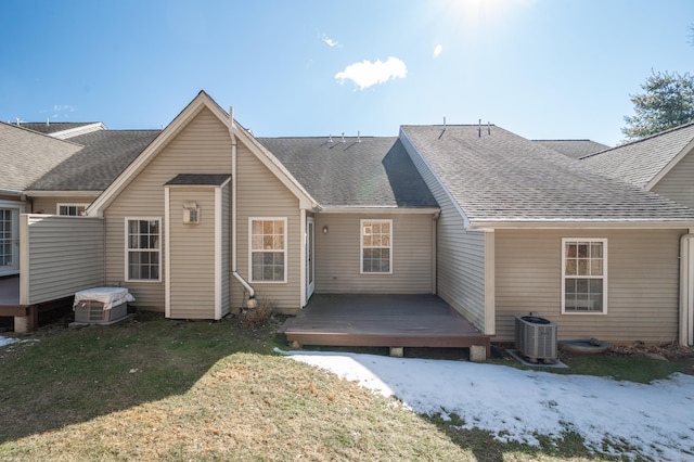 rear view of property with roof with shingles, a lawn, a deck, and central AC unit