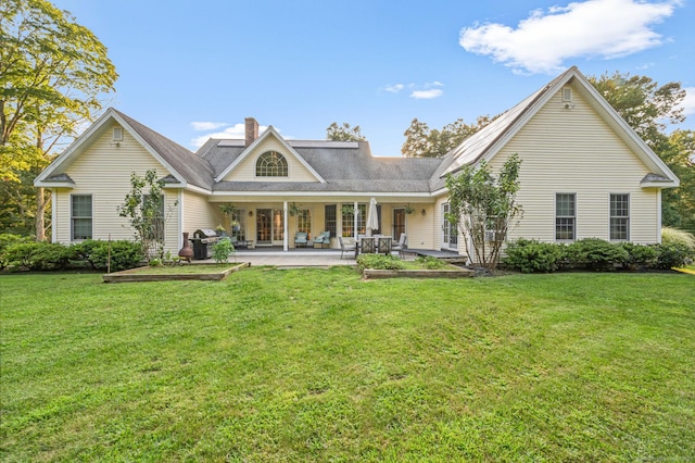 rear view of house featuring a patio, a lawn, and a chimney