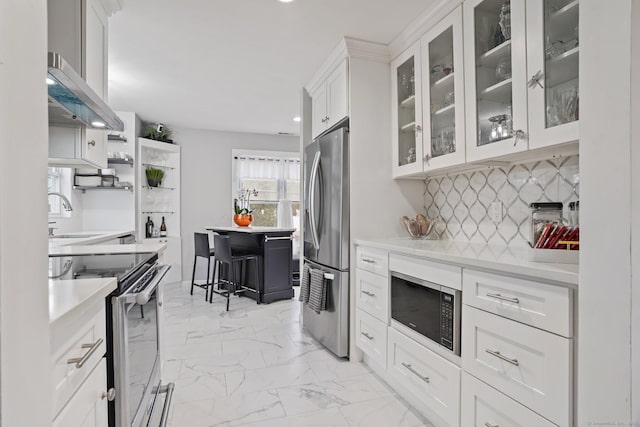 kitchen featuring marble finish floor, stainless steel appliances, light countertops, backsplash, and a sink