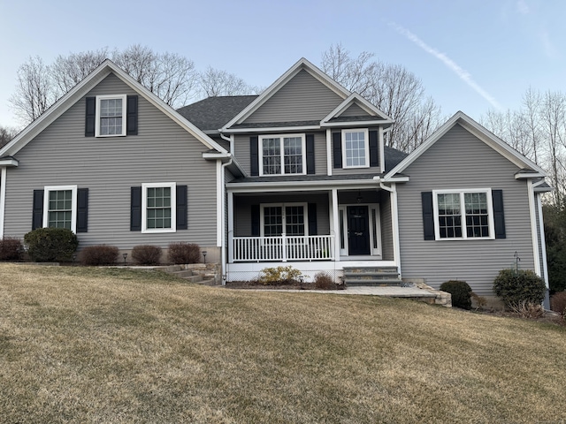 traditional-style home featuring a porch and a front yard