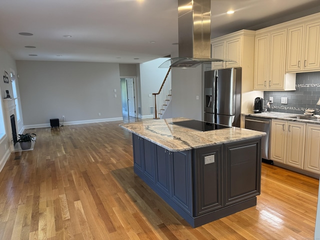 kitchen featuring tasteful backsplash, open floor plan, light wood-style floors, island range hood, and stainless steel appliances