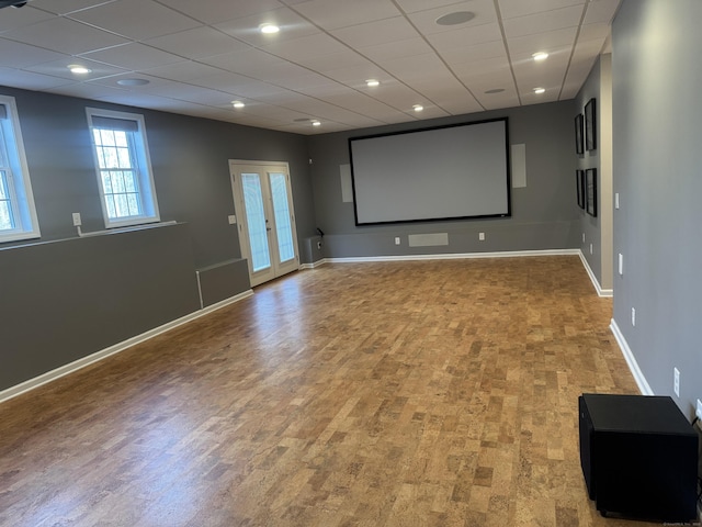 cinema featuring recessed lighting, wood finished floors, baseboards, and a paneled ceiling