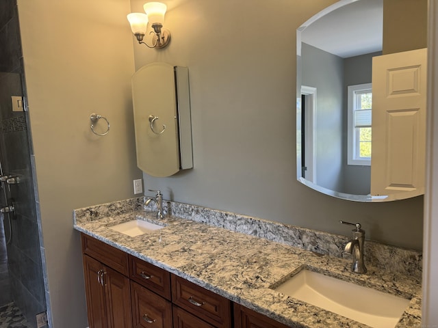 full bath featuring a sink, tiled shower, and double vanity