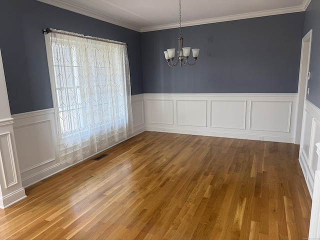 unfurnished dining area featuring a wealth of natural light, visible vents, an inviting chandelier, and wood finished floors