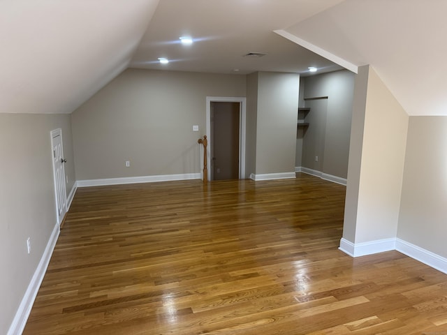 bonus room featuring vaulted ceiling, wood finished floors, visible vents, and baseboards