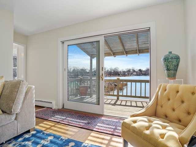 entryway featuring a wealth of natural light, a baseboard heating unit, a water view, and wood finished floors