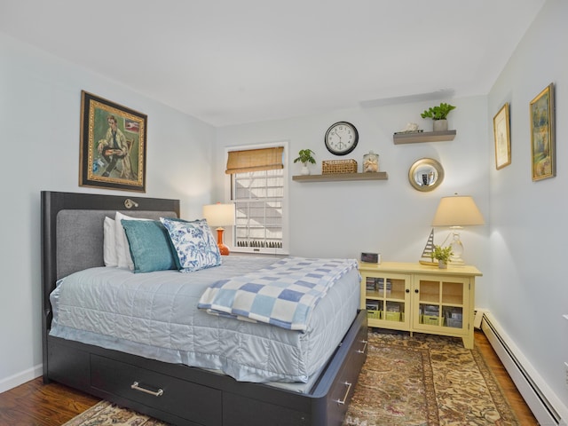 bedroom featuring wood finished floors, baseboards, and a baseboard radiator