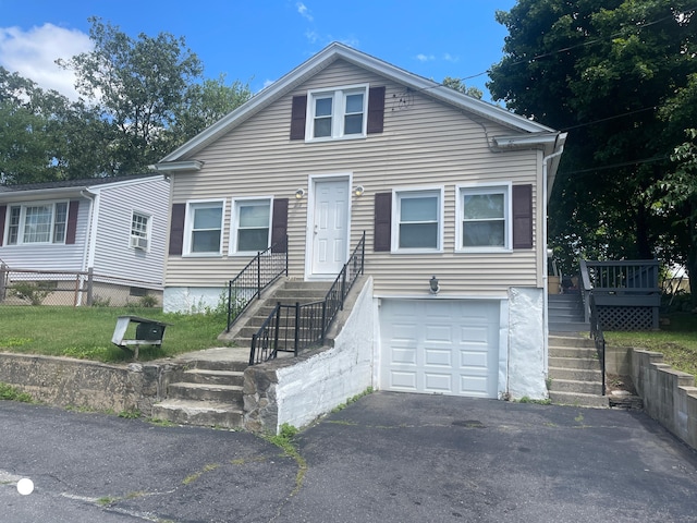 bungalow-style home with aphalt driveway, an attached garage, fence, cooling unit, and stairs