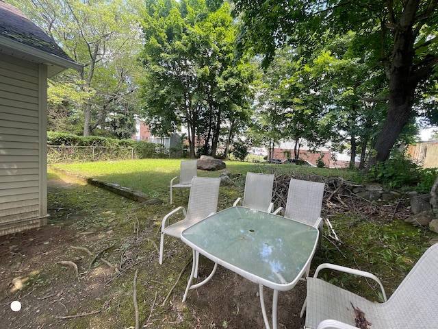 view of yard featuring outdoor dining area and fence