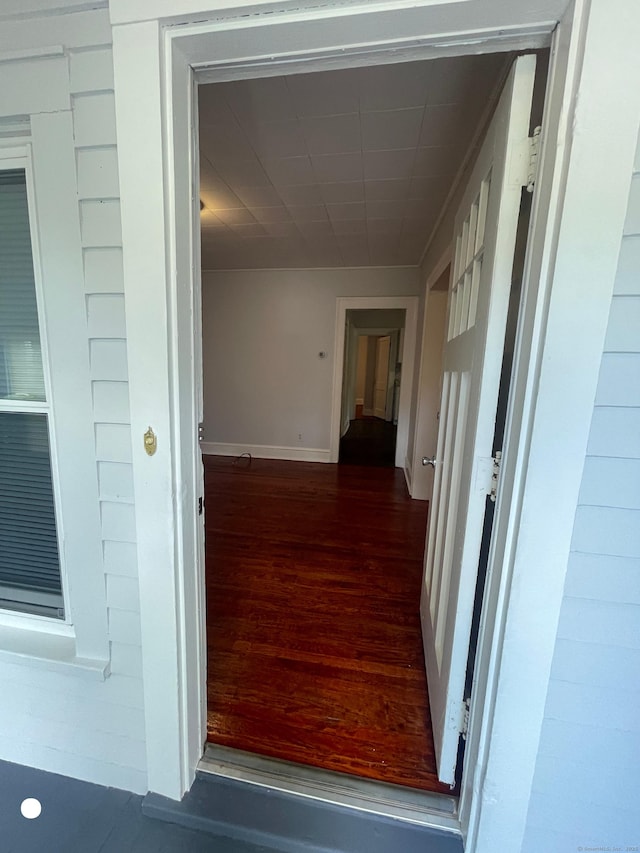 hallway featuring wood finished floors and baseboards