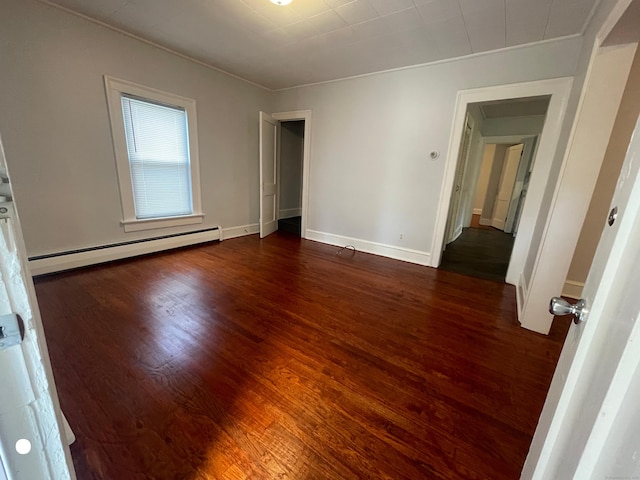 unfurnished bedroom with baseboards, baseboard heating, and wood finished floors