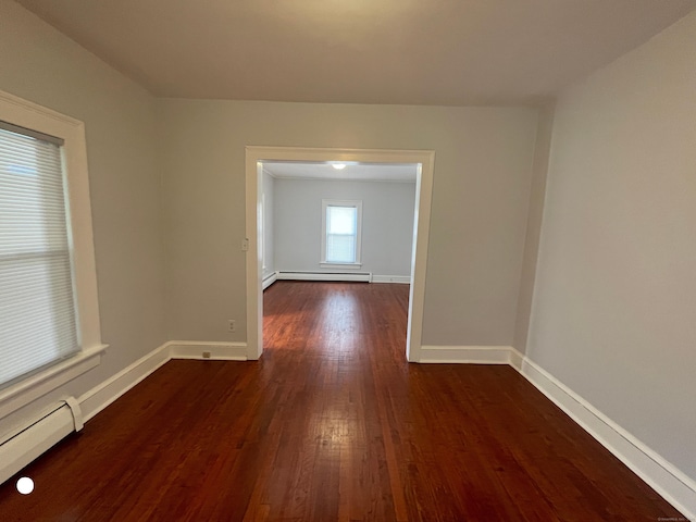 empty room featuring a baseboard radiator, baseboards, baseboard heating, and dark wood-style flooring