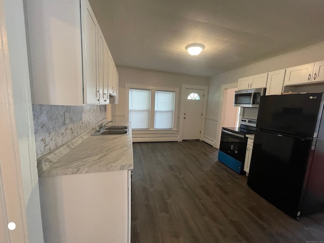 kitchen with dark wood finished floors, stainless steel appliances, light countertops, white cabinetry, and a sink