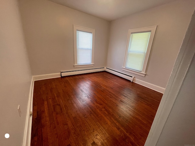 unfurnished room with plenty of natural light, baseboards, and dark wood-type flooring