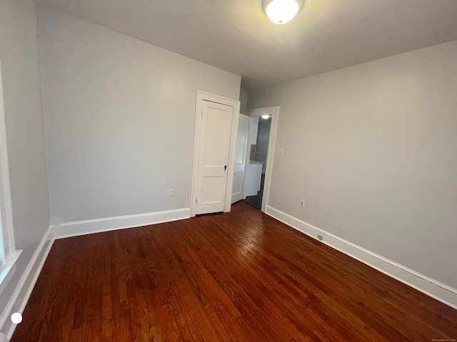 empty room featuring dark wood-style floors and baseboards