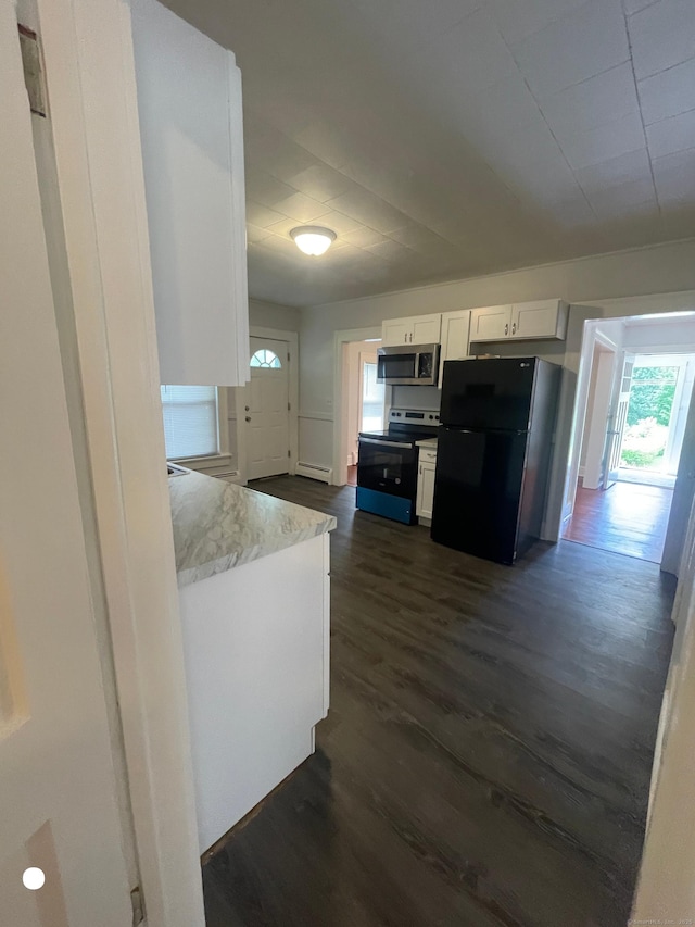 kitchen with stainless steel appliances, baseboard heating, dark wood-type flooring, white cabinets, and light stone countertops