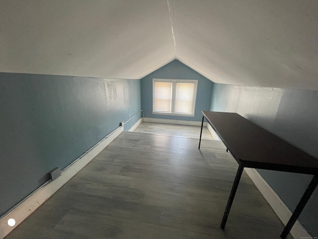 additional living space featuring vaulted ceiling, baseboards, and wood finished floors