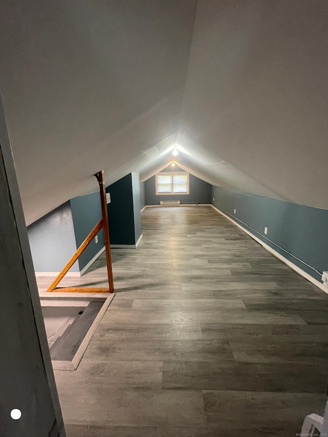 additional living space featuring lofted ceiling and wood finished floors