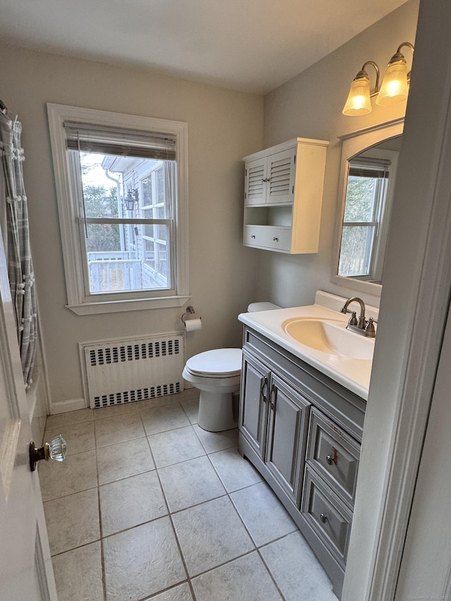 bathroom featuring baseboards, radiator, toilet, tile patterned floors, and vanity