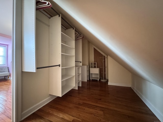 bonus room with lofted ceiling, dark wood-style floors, and baseboards