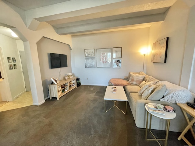 carpeted living room featuring arched walkways, beam ceiling, and baseboards