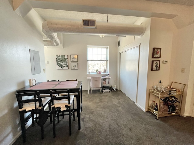 dining room with electric panel, dark carpet, and visible vents