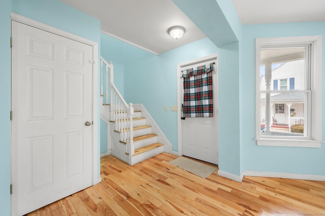 entrance foyer with wood-type flooring, baseboards, and stairs