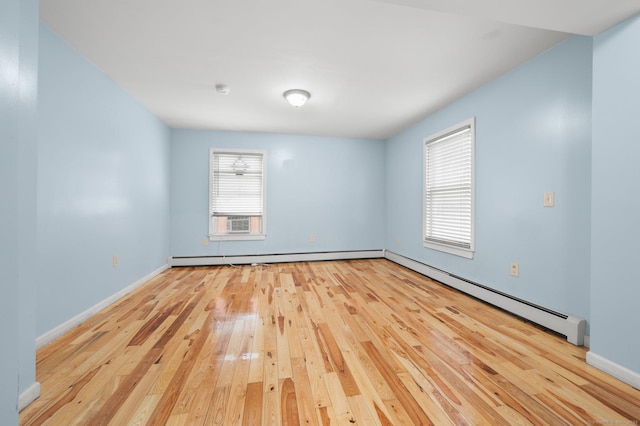 unfurnished room featuring light wood-type flooring, a baseboard radiator, and baseboards