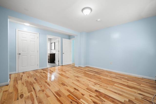 spare room featuring light wood-style floors and baseboards