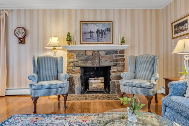 living area with a baseboard heating unit, wood finished floors, a fireplace, wallpapered walls, and baseboard heating