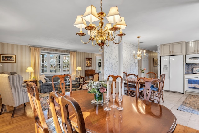 dining space with wallpapered walls, a notable chandelier, and light tile patterned floors