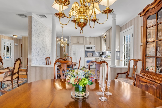 dining space with crown molding, visible vents, ornate columns, and a chandelier