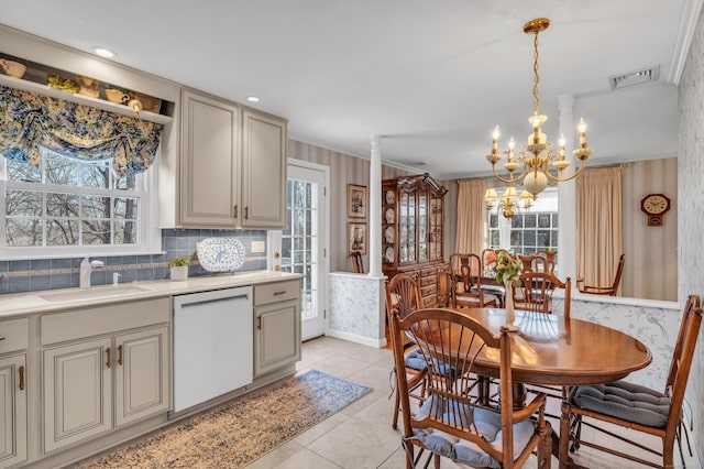 kitchen with visible vents, wallpapered walls, light countertops, white dishwasher, and a sink