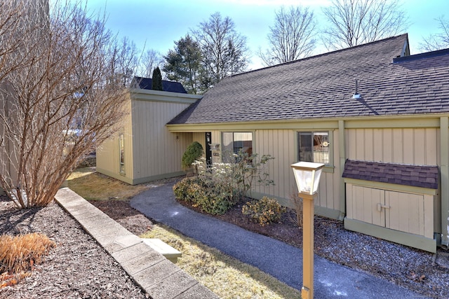 view of side of home featuring roof with shingles
