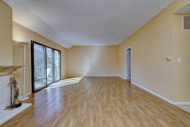 unfurnished living room with lofted ceiling, baseboards, and wood finished floors