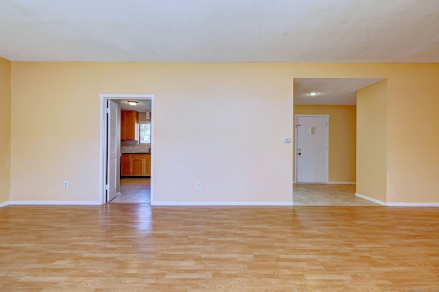 unfurnished room featuring light wood-style floors and baseboards
