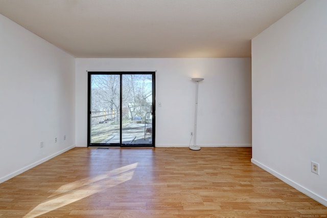 unfurnished room with light wood-style flooring and baseboards